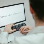 A person typing on a laptop showing the provocative message 'break the internet'.