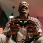 Excited man holding a controller while immersed in a video game, enjoying leisure time indoors.